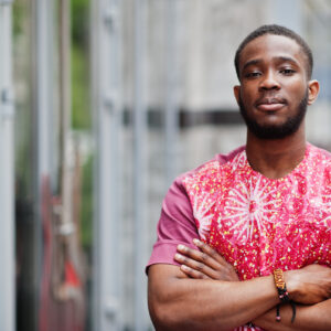 Portrait of a black young man wearing african traditional red colorful clothes.